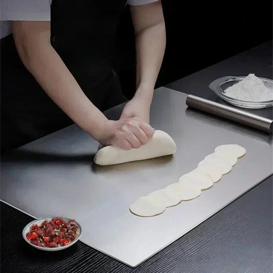 Personne roulant de la pâte sur la planche à découper, plat avec farine d'un côté et plat avec garniture de l'autre.